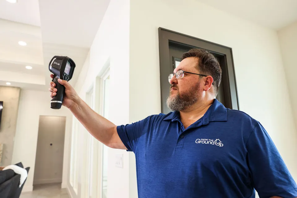 Troy using a thermal imaging camera during an interior inspection